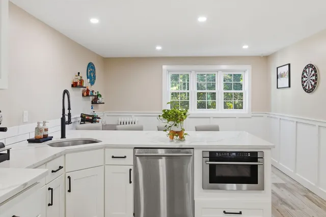 a kitchen with stainless steel appliances a stove and white cabinets