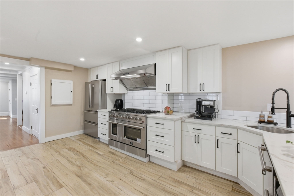 12 Salem Street, Unit 2 Haverhill, MA 01835 - Photo 12 of 34 a kitchen with stainless steel appliances kitchen island granite countertop a sink cabinets and wooden floor