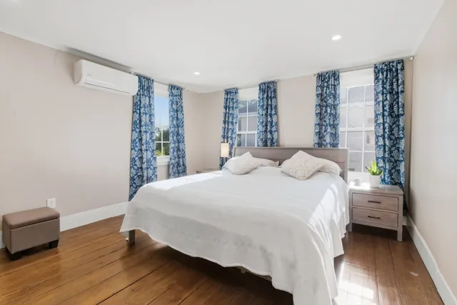 a bedroom with a bed and a large window