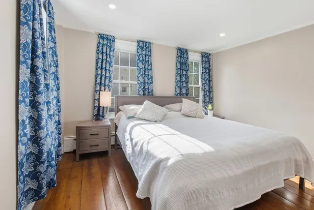 a large bed sitting in a bedroom next to a window