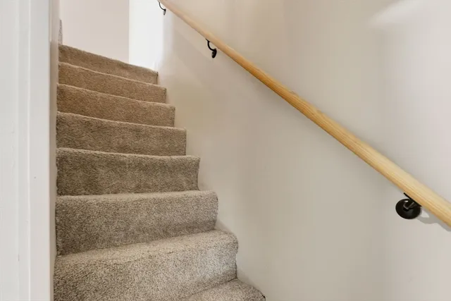 a view of staircase with white walls and white door