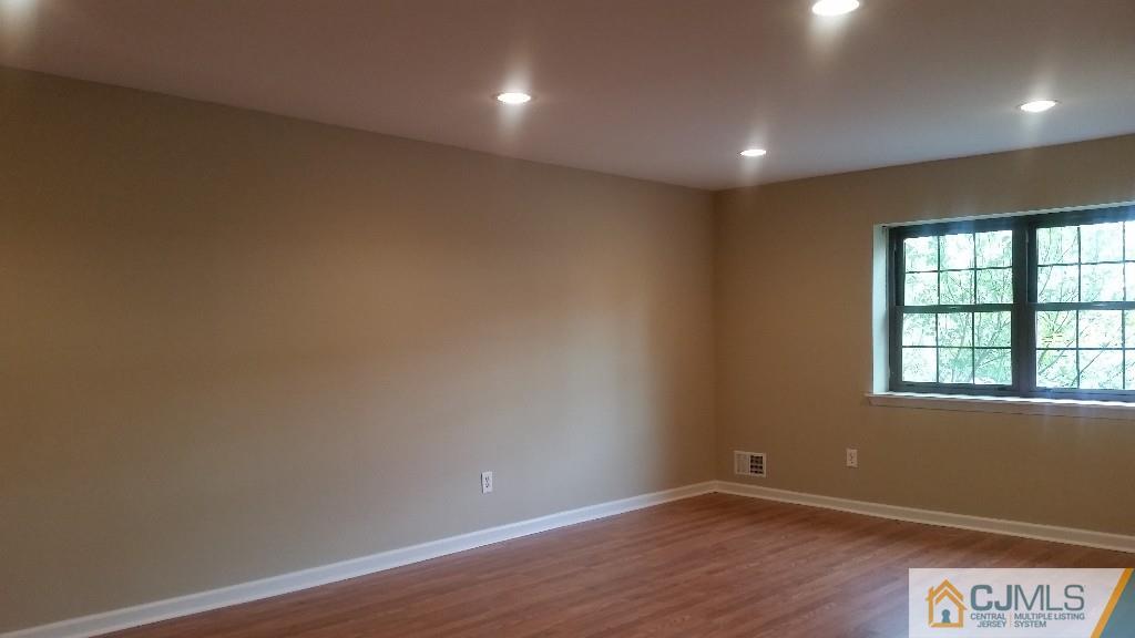 8305 Hana Road Edison, NJ 08817 - Photo 7 of 20 an empty room with wooden floor and windows