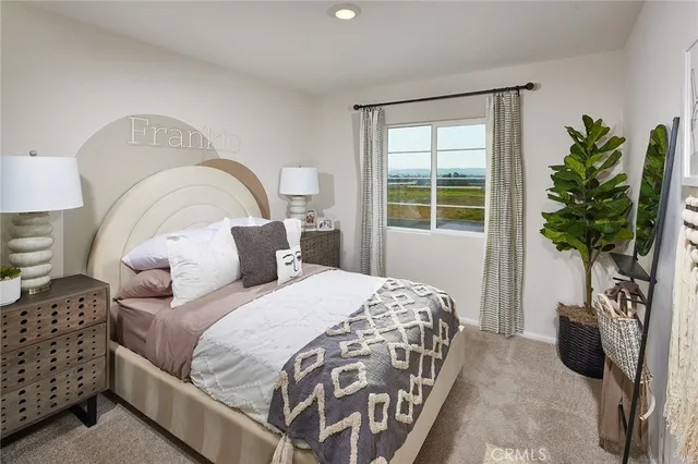 a bedroom with bed and a potted plant