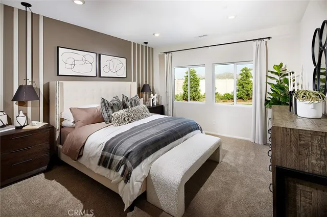 a bedroom with a large bed and a potted plant