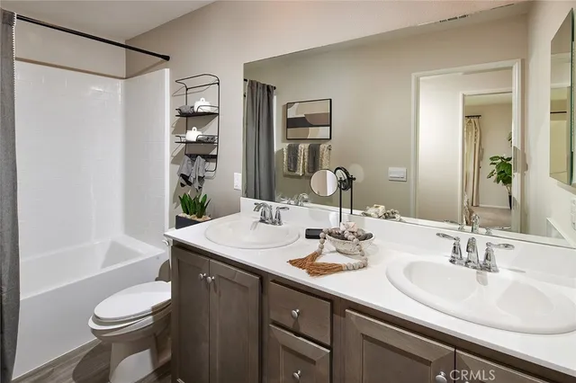 a bathroom with a double vanity sink toilet and shower