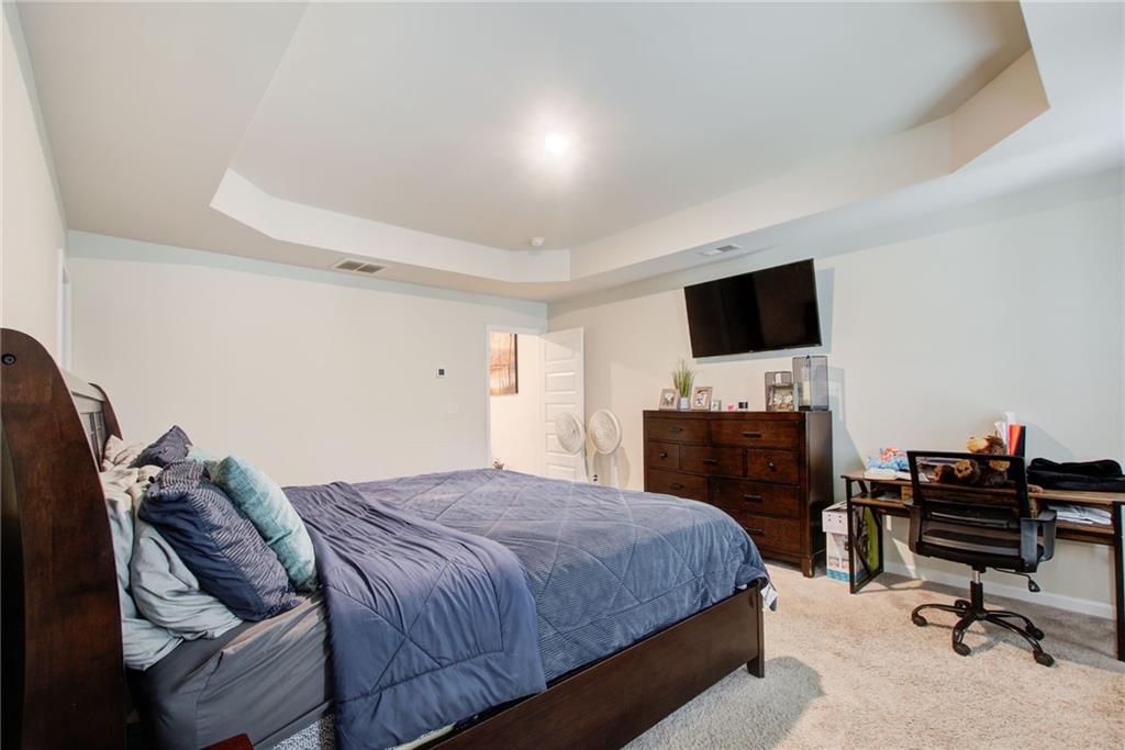 11898 Lovejoy Crossing Boulevard Hampton, GA 30228 - Photo 16 of 30 a bedroom with a bed and a flat screen tv