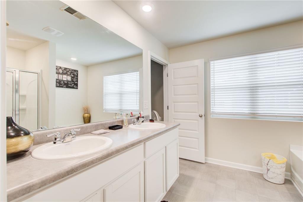 11898 Lovejoy Crossing Boulevard Hampton, GA 30228 - Photo 18 of 30 a bathroom with a double vanity sink and a mirror