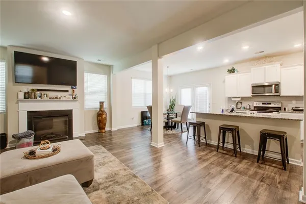 a kitchen with granite countertop a refrigerator stove microwave and cabinets
