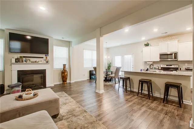 a kitchen with granite countertop a refrigerator stove microwave and cabinets