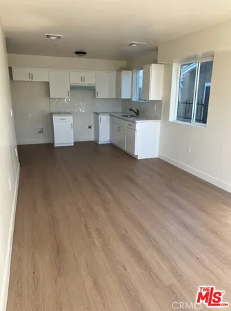 a large kitchen with cabinets and wooden floor