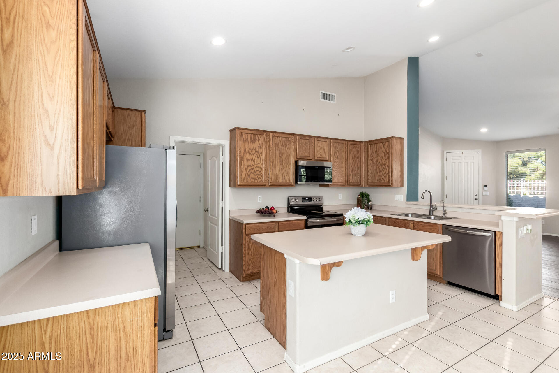 939 South Roca Street Gilbert, AZ 85296 - Photo 15 of 40 a kitchen with a sink a stove a refrigerator and cabinets