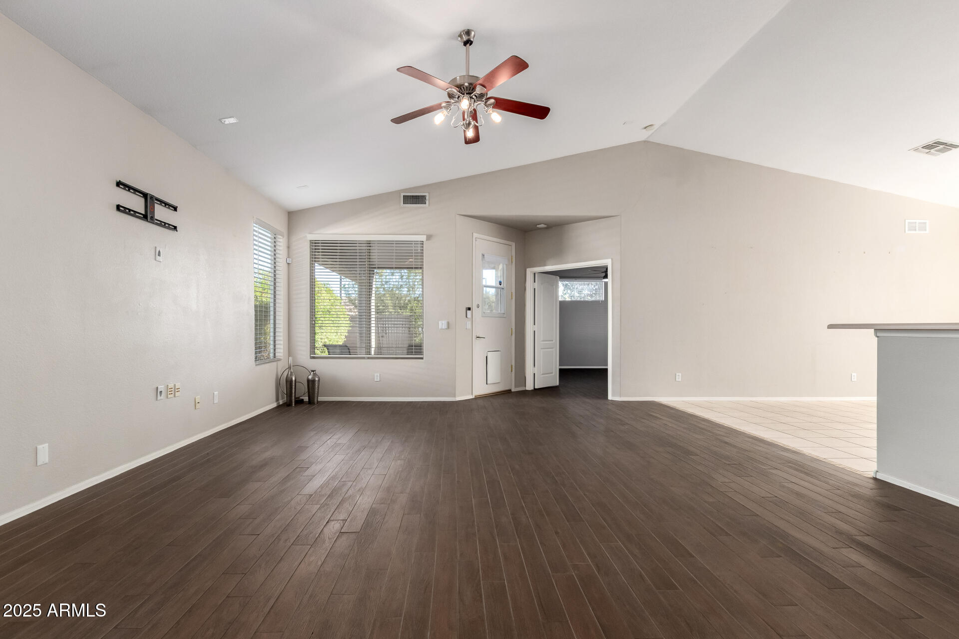 939 South Roca Street Gilbert, AZ 85296 - Photo 6 of 40 an empty room with wooden floor and a ceiling fan