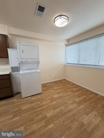 a view of a room with wooden floor and electronic appliances
