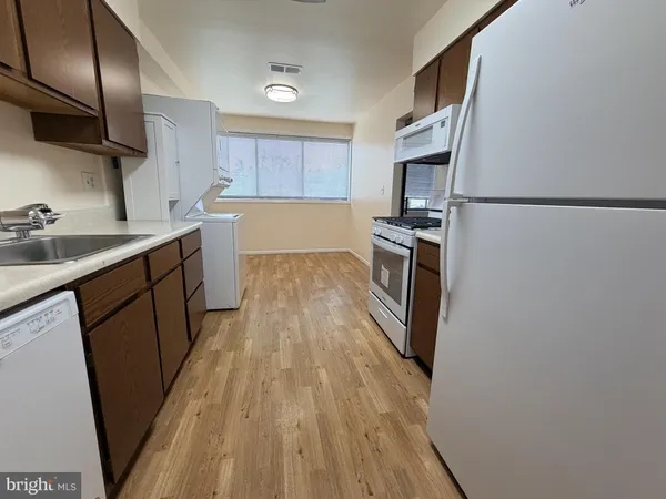 a kitchen with granite countertop a refrigerator stove and sink