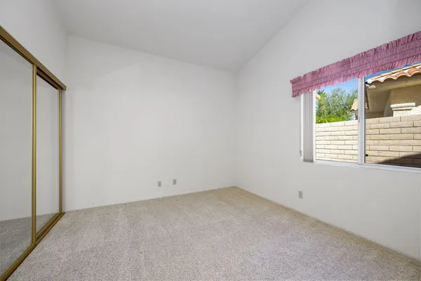 a view of an empty room with a kitchen