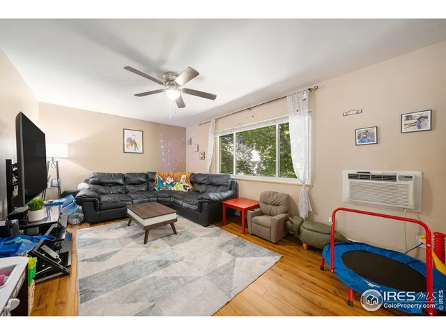a living room with furniture a window and a flat screen tv