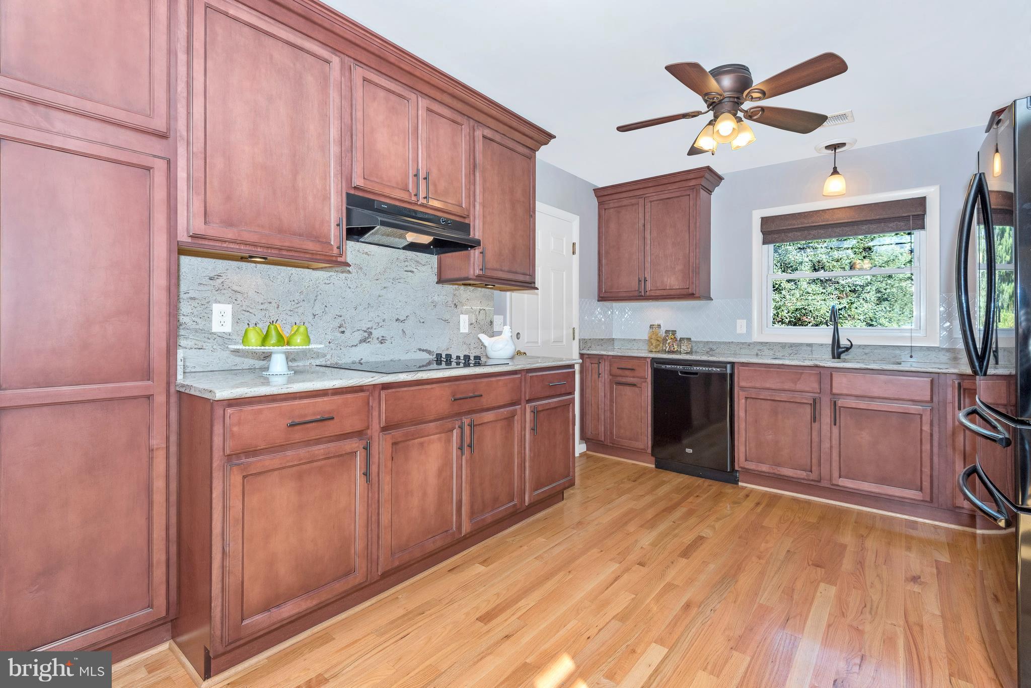 7311 Ridge Road Frederick, MD 21702 - Photo 10 of 30 a kitchen with stainless steel appliances granite countertop a sink a stove a refrigerator cabinets and wooden floor