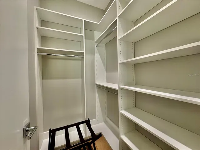 a view of walk in closet with empty racks