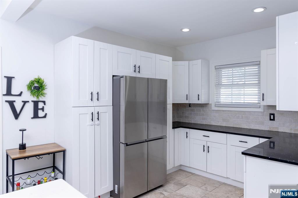 126 Ridge Avenue Bloomfield, NJ 07003 - Photo 15 of 45 a kitchen with a refrigerator a sink and cabinets