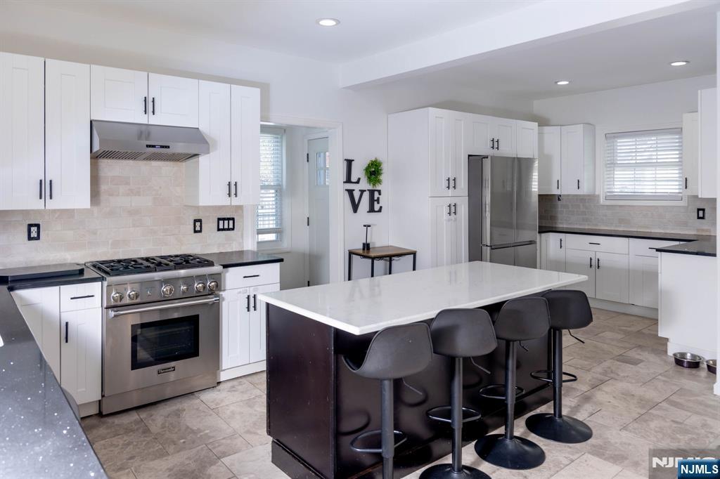 126 Ridge Avenue Bloomfield, NJ 07003 - Photo 9 of 45 a kitchen with stainless steel appliances a stove a sink a refrigerator and white cabinets