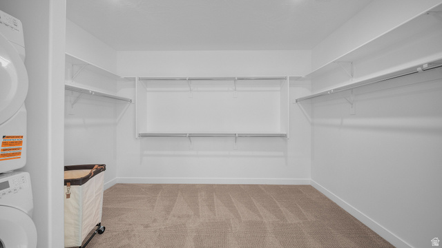 324 North Rhyolite Drive, Unit 87 Hurricane, UT 84737 - Photo 20 of 33 Walk in closet featuring light colored carpet and stacked washer / dryer