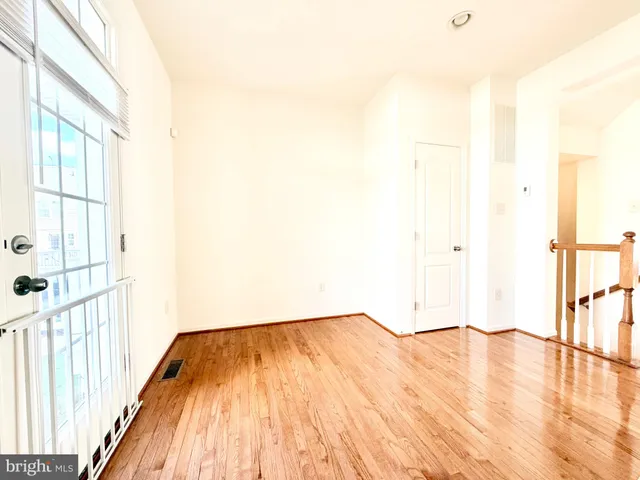 a view of a room with wooden floor and a window