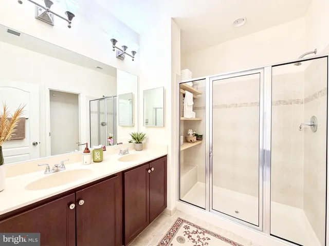 a bathroom with a double vanity sink mirror and shower