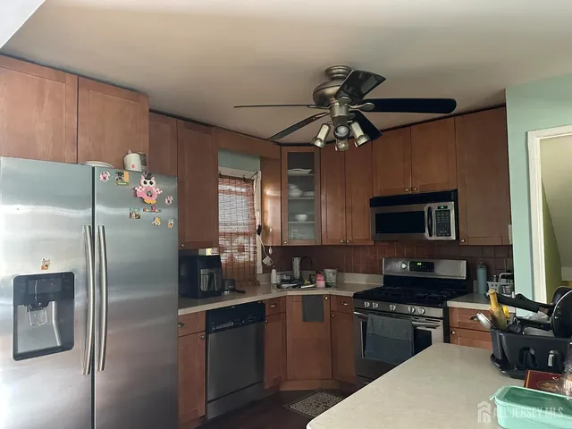 a kitchen with stainless steel appliances granite countertop a refrigerator a stove and a sink