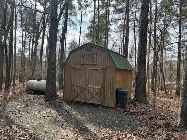 a wooden house with tall trees in the background