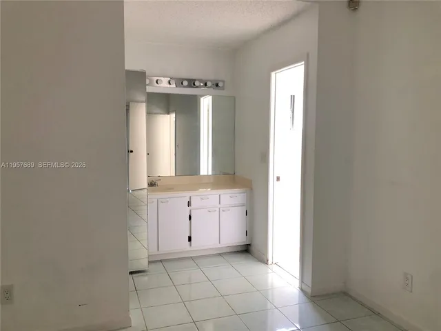 a spacious bathroom with a mirror sink and cabinets