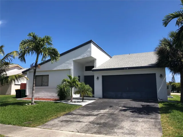 a front view of house with a garden