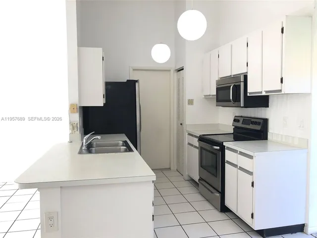 a kitchen with stainless steel appliances a stove refrigerator sink and cabinets