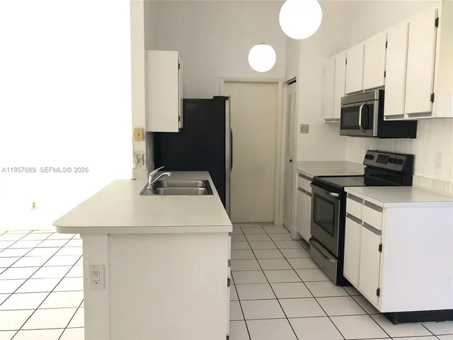 a kitchen with stainless steel appliances a stove refrigerator sink and microwave