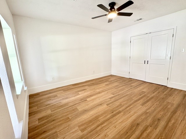 3726 Heatherbrook Drive Houston, TX 77045 - Photo 11 of 17 a view of empty room with wooden floor and fan