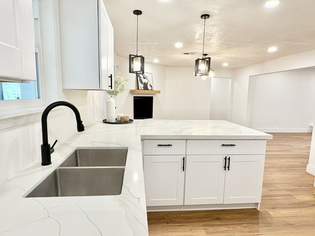 3726 Heatherbrook Drive Houston, TX 77045 - Photo 4 of 17 a kitchen with a sink a stove and white cabinets with wooden floor