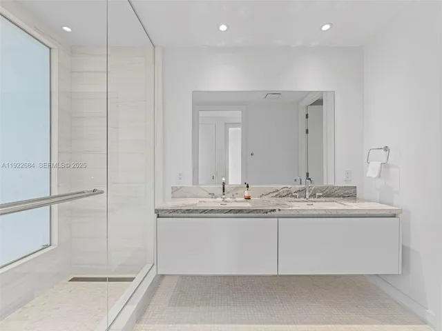a bathroom with a granite countertop sink a mirror and a shower