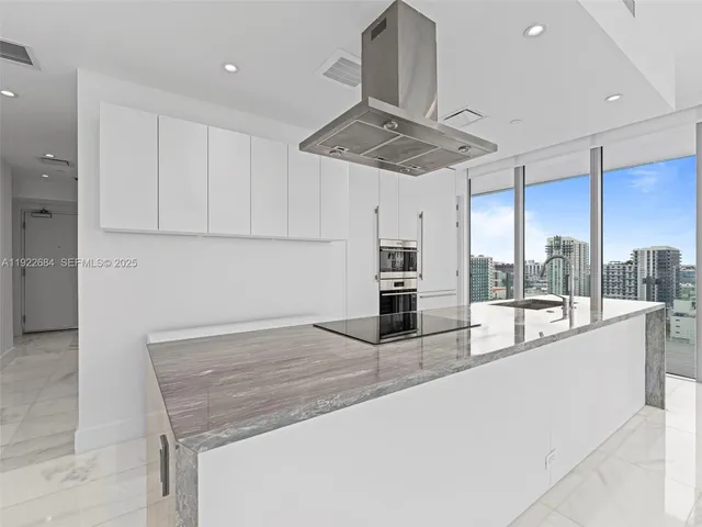 a kitchen with stainless steel appliances granite countertop a sink a stove and cabinets