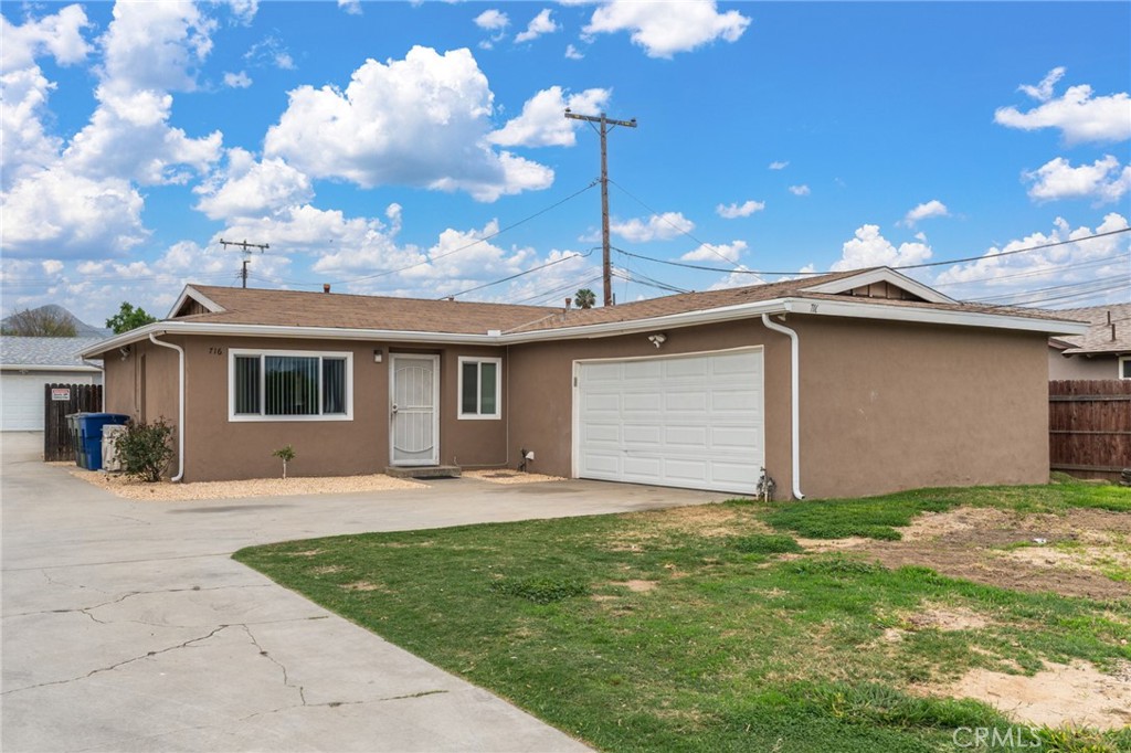 a front view of a house with a garden and yard