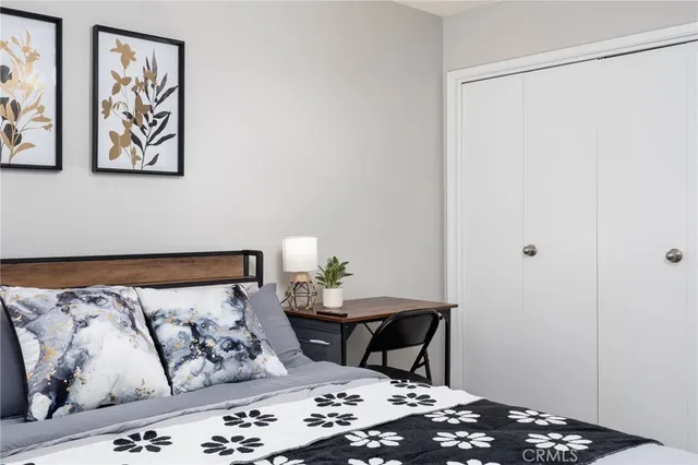 a bedroom with a bed and painting on the wall