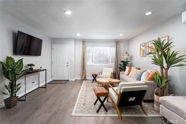 a living room with furniture a flat screen tv and a potted plant