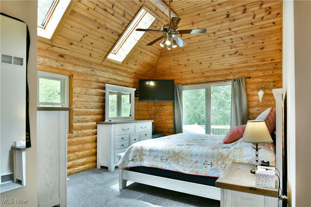 2907 Bushnell Campbell Road Fowler, OH 44418 - Photo 23 of 49 Carpeted bedroom featuring a skylight, multiple windows, rustic walls, high vaulted ceiling, and wood ceiling