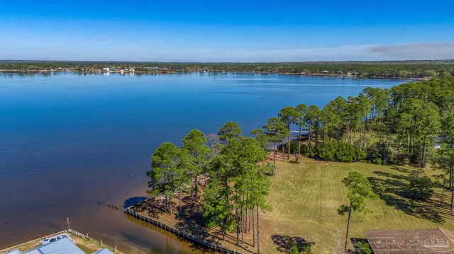 a view of a lake with lawn chairs