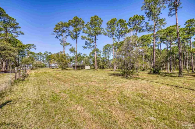 a view of a swimming pool with outdoor seating and a yard