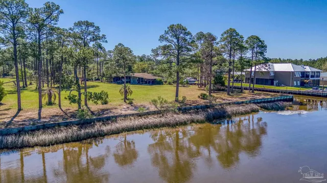 an aerial view of residential houses with outdoor space and lake view