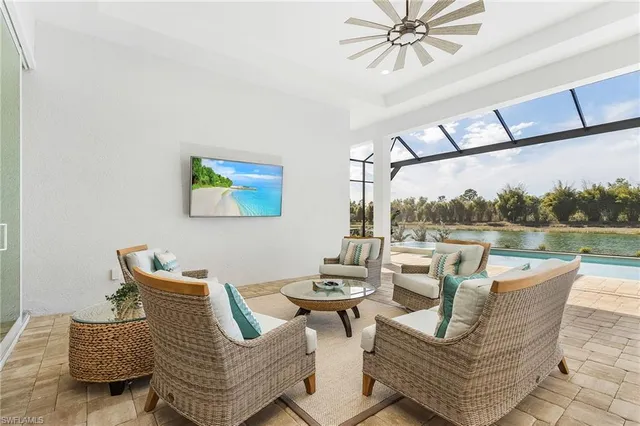 a living room with furniture a rug potted plant and a large window