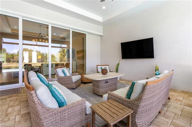 a living room with furniture a flat screen tv and a floor to ceiling window