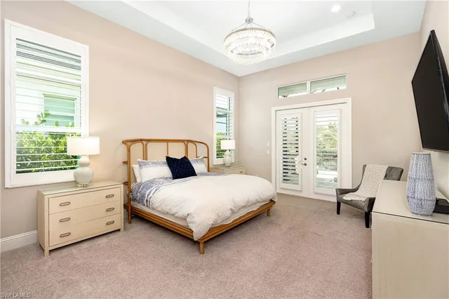 a bedroom with a bed flat screen tv and a large window