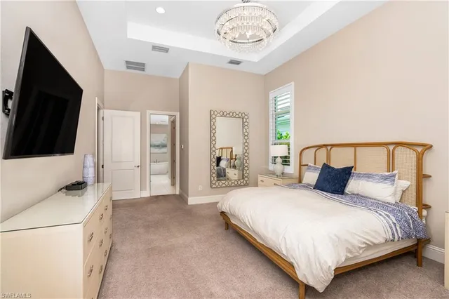 a bedroom with a bed and a flat tv screen on dresser