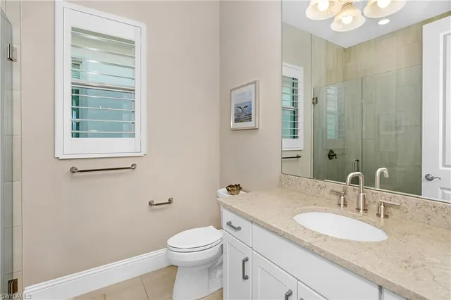 a bathroom with a granite countertop sink a toilet and a mirror