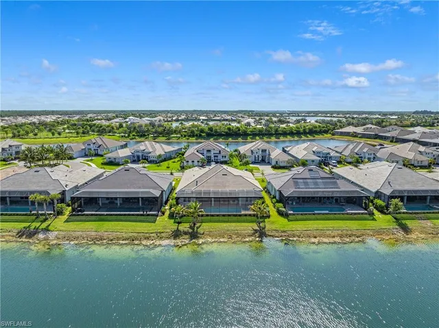 an aerial view of residential houses with yard and ocean view